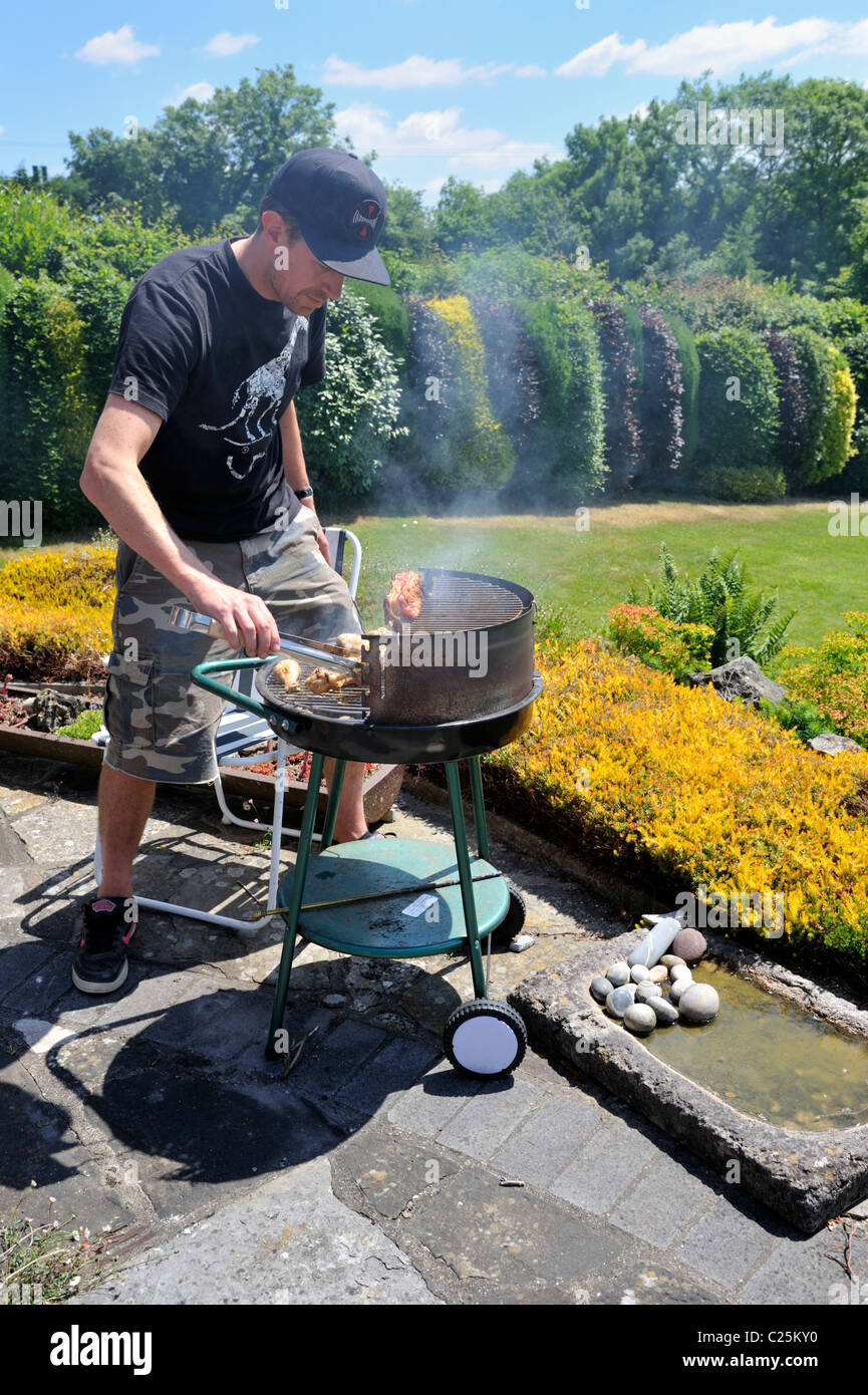 L'homme à la cuisson des aliments sur un barbecue Banque D'Images