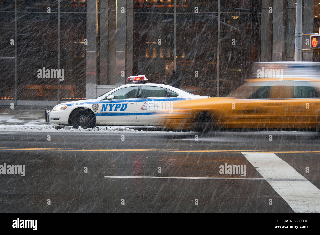 Taxi et voiture de police à New York neige. Motion Blur en taxi. Times Square, New York. L'arrêt auto de police dépassé par taxi rapide. Banque D'Images