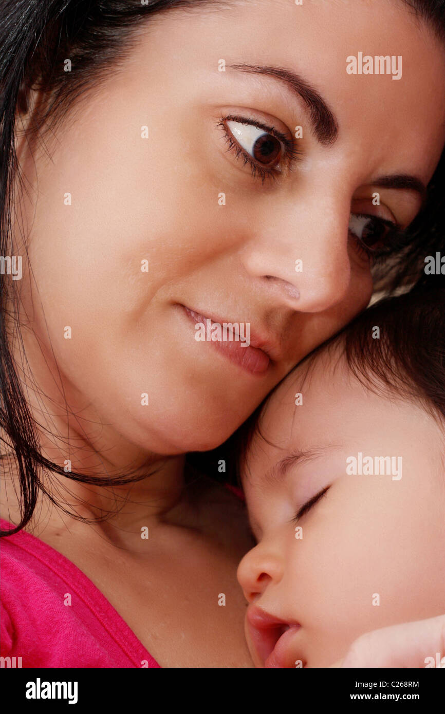 Young mother hugging son bébé pendant le sommeil Banque D'Images