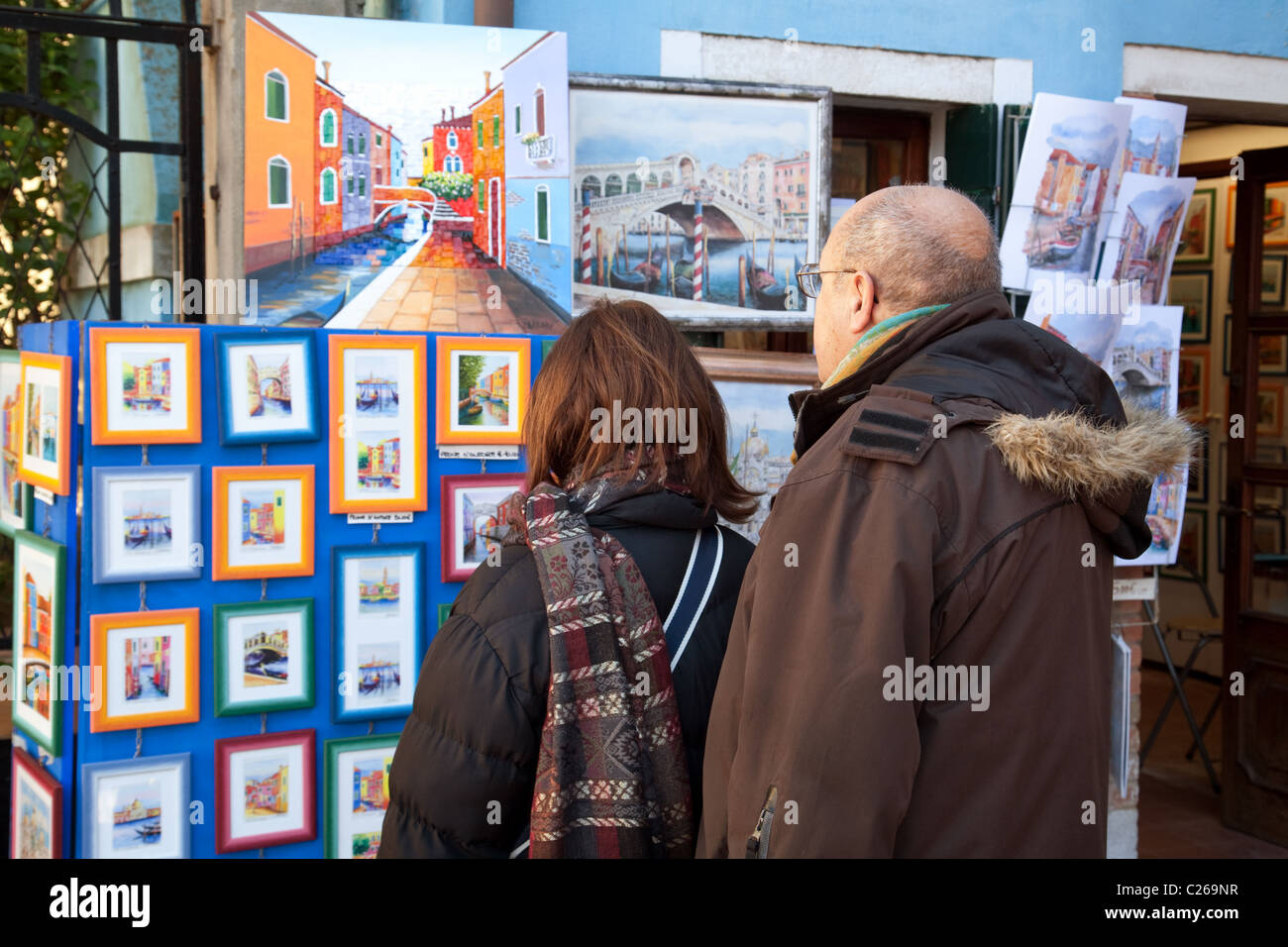 Les personnes à la recherche de photos en vente sur un étal, artistes de rue, village de Burano Venise, Italie Banque D'Images