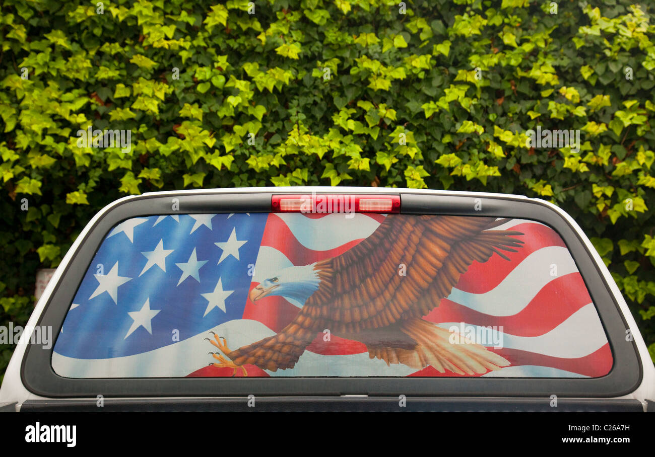 Drapeau américain et de l'Aigle dans la fenêtre d'une camionnette Banque D'Images