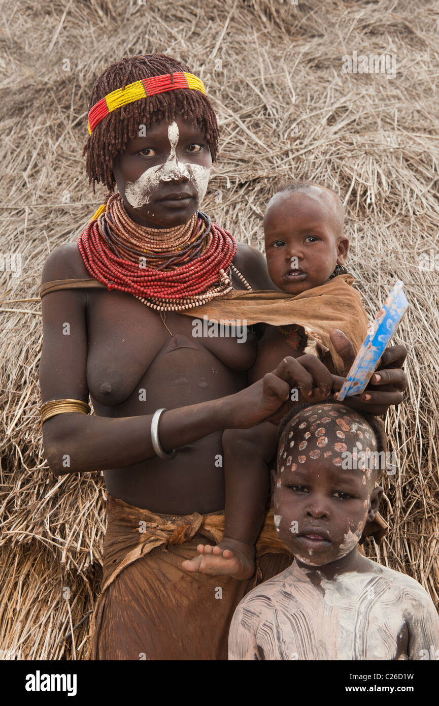 Karo femme avec beaucoup de colliers colorés et peintures faciales avec un bébé et un enfant, de l'Éthiopie Banque D'Images