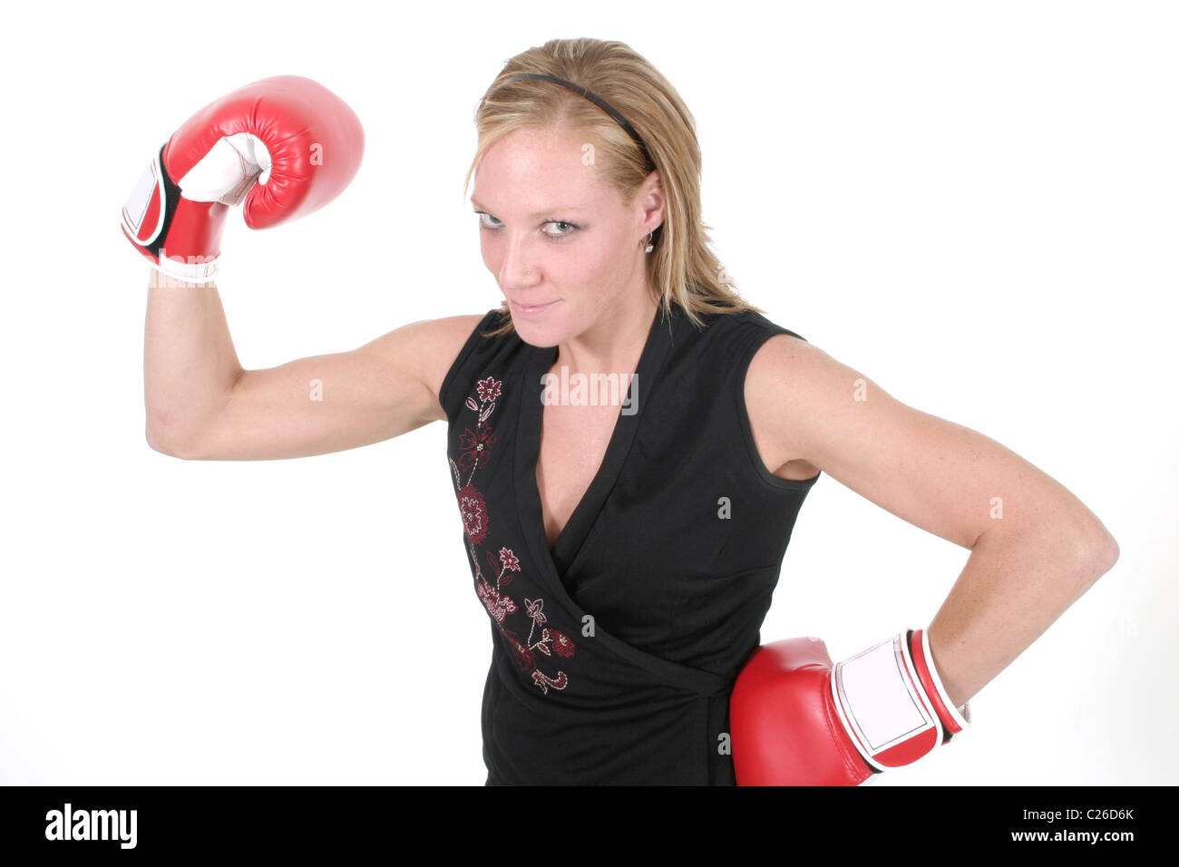 Belle blonde femme d'affaires exécutif met sur le gants de boxe pour faire la bataille dans le monde de l'entreprise. Banque D'Images