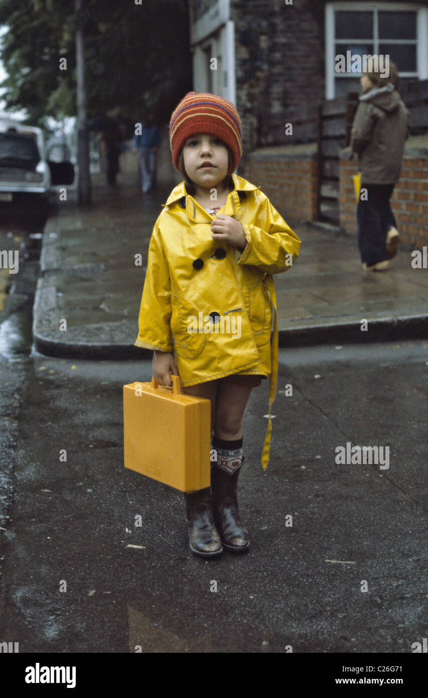 Young Girl wearing impermeable jaune tenant son cartable scolaire en plastique jaune et des bottes en caoutchouc Photo Stock Alamy