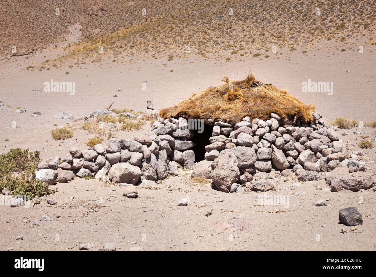 Un abri en pierre du berger de lamas / refuge avec toit d'herbe dans le désert dans le sud-ouest de la Bolivie, l'Amérique du Sud. Banque D'Images
