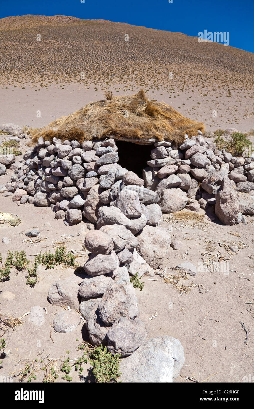 Un abri en pierre du berger de lamas / refuge avec toit d'herbe dans le désert dans le sud-ouest de la Bolivie, l'Amérique du Sud. Banque D'Images