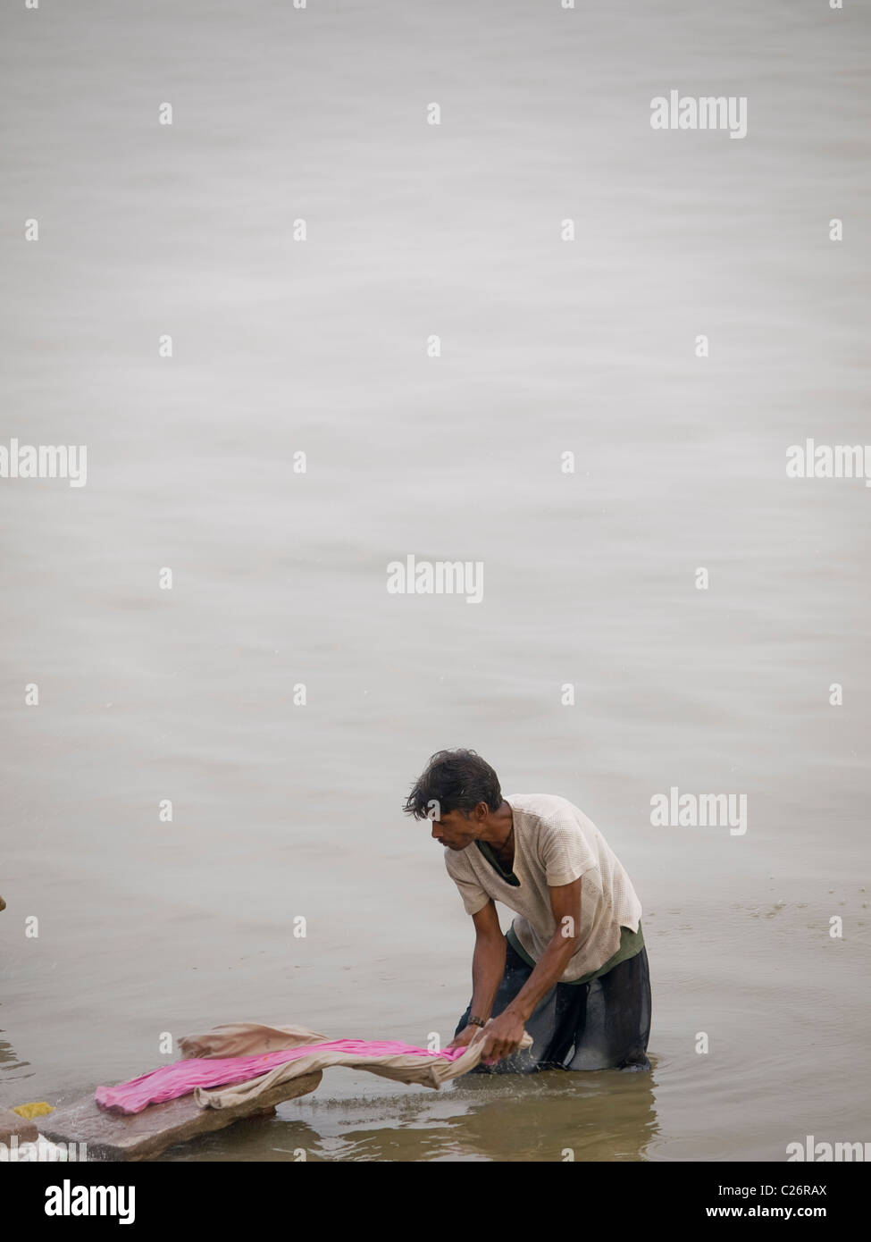 Homme faire la lessive à l'un des ghats de Varanasi, Inde Banque D'Images