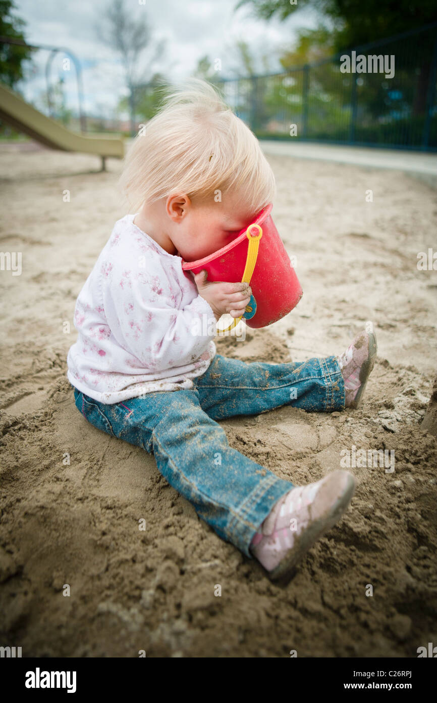 1 ans, fille en aire de jeux avec jouets Sable Sandbox Banque D'Images
