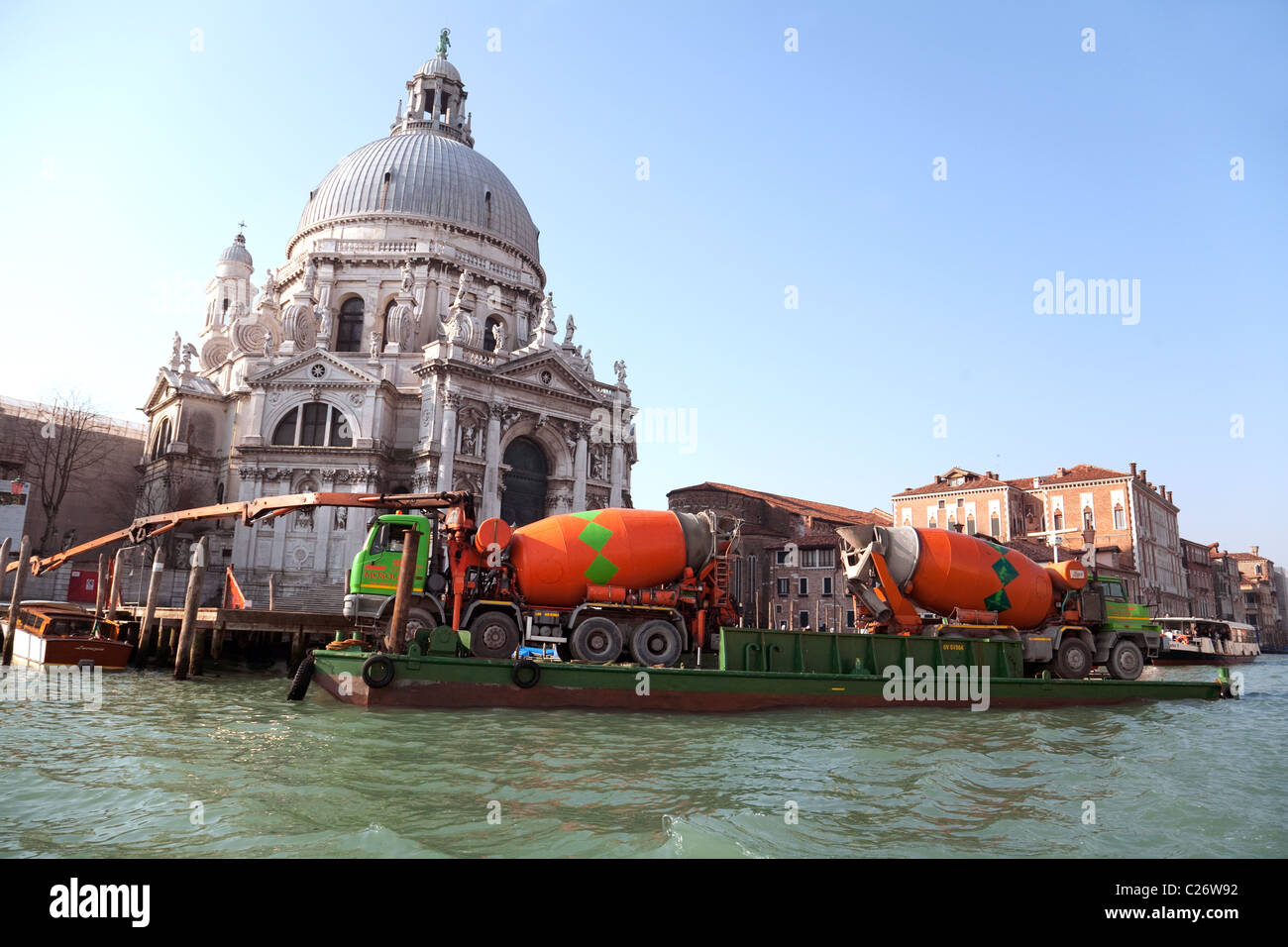 Restauration et réparation avec deux mélangeurs de ciment sur une péniche, à l'église de Santa Maria della Salute, Grand Canal, Venise, Italie Banque D'Images