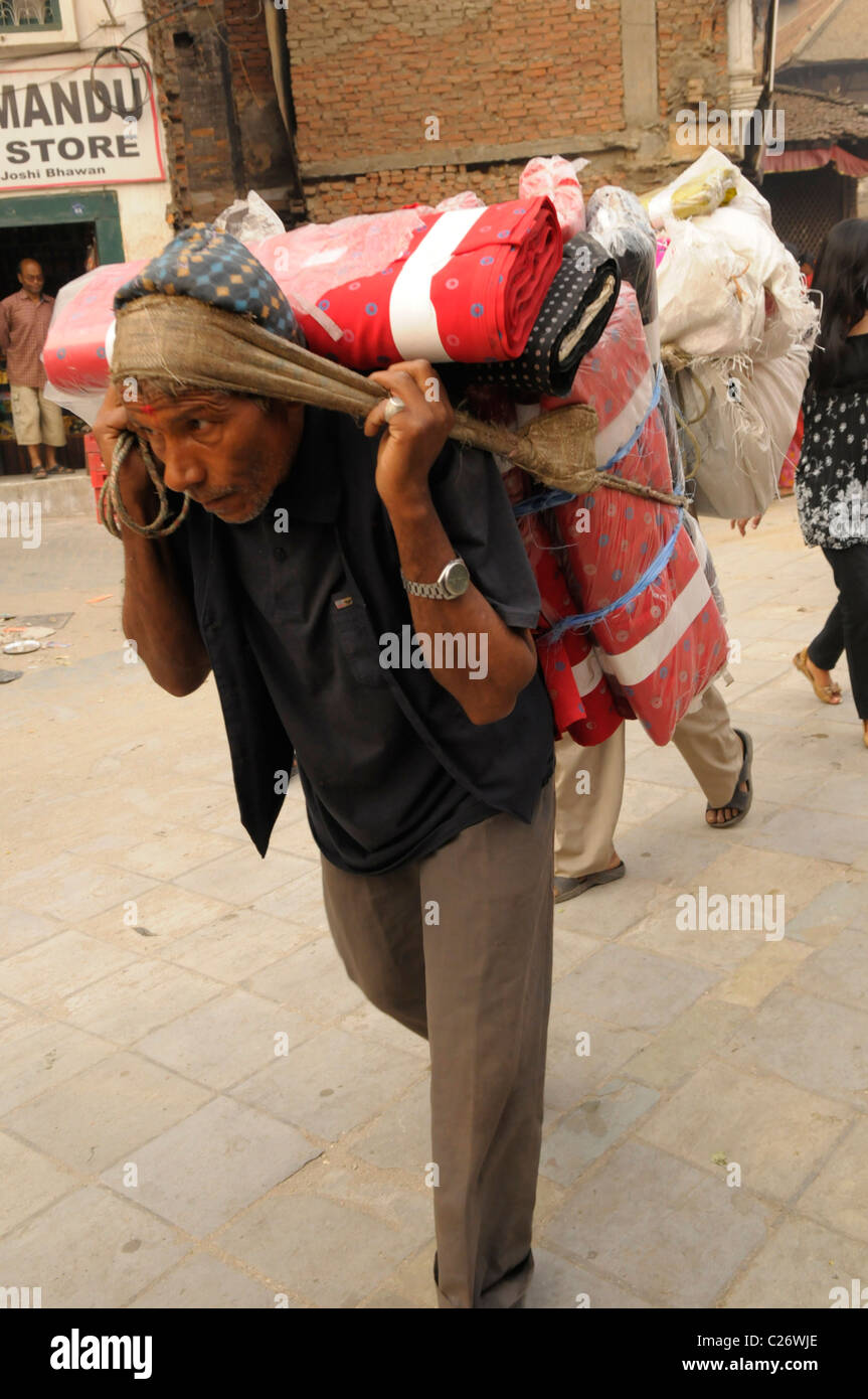Manoeuvre sherpa portant de lourdes charge , la vie , les Népalais à Katmandou , rue de Katmandou au Népal , vie Banque D'Images