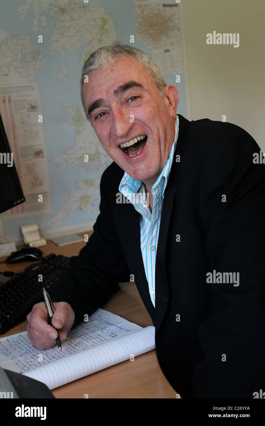 Les entreprises plus âgées homme photographié dans le travail à domicile dans son bureau à Southampton, Hampshire, Royaume-Uni. Banque D'Images