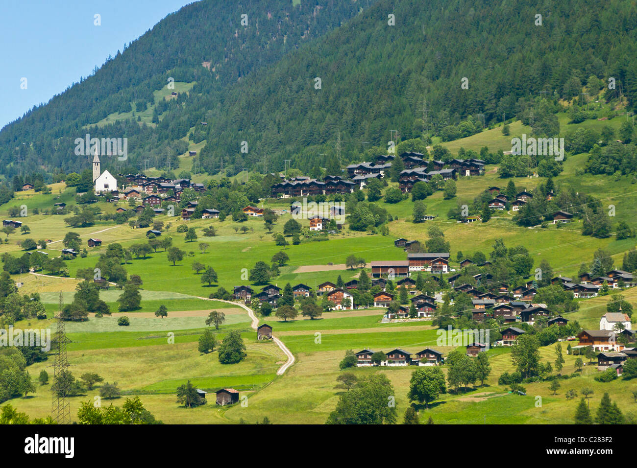 Village walser pittoresque avec petite église et maisons traditionnelles en bois avec de larges toits dans les Alpes suisses Banque D'Images