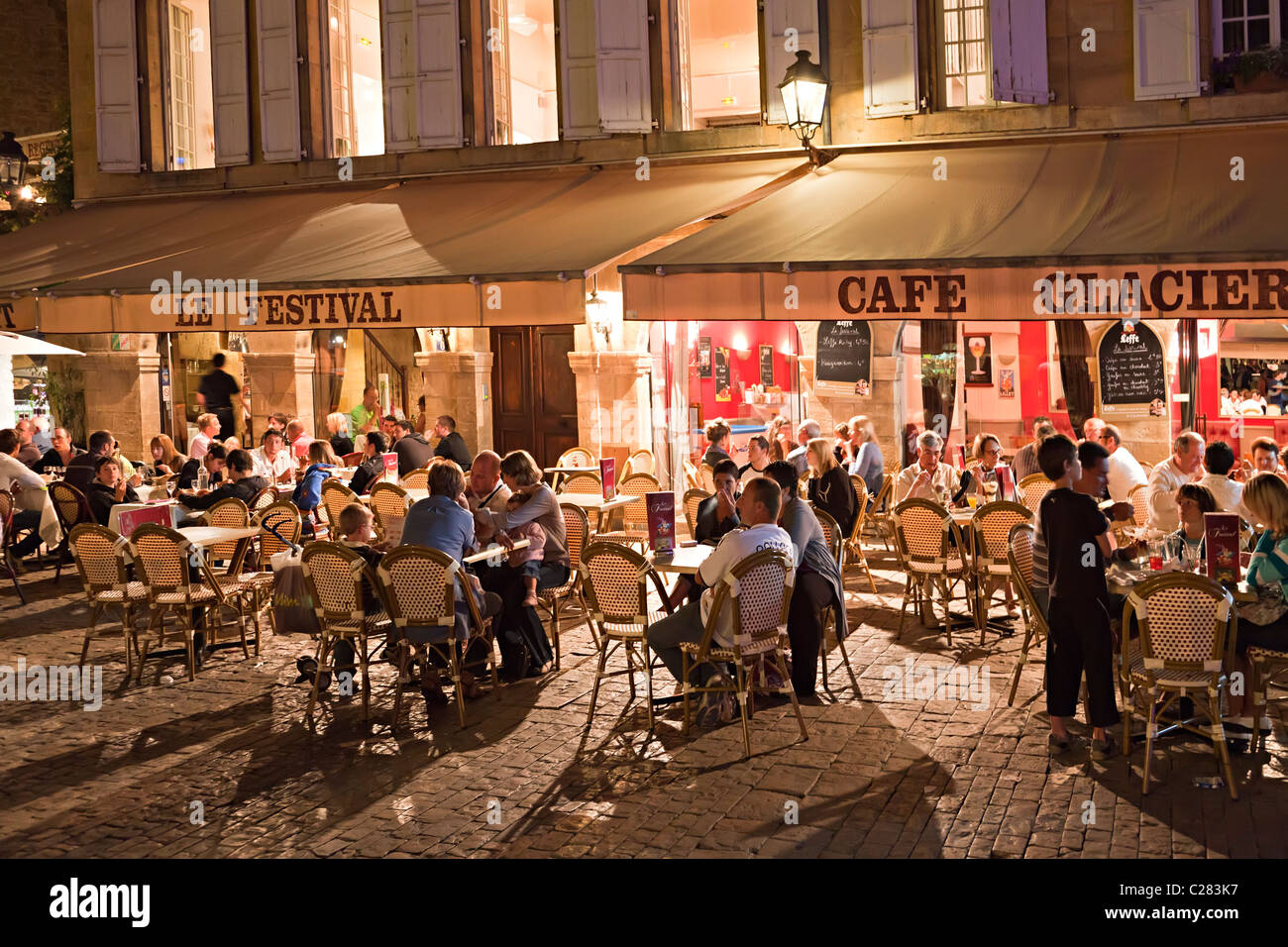 Les gens au café tables de town square la nuit Sarlat Dordogne France Banque D'Images