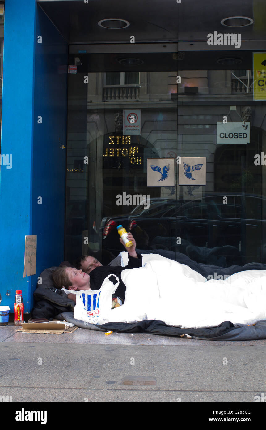 Un couple de sans-abri dormir dans la porte en face de l'Hôtel Ritz à Piccadilly, Londres, Angleterre Banque D'Images