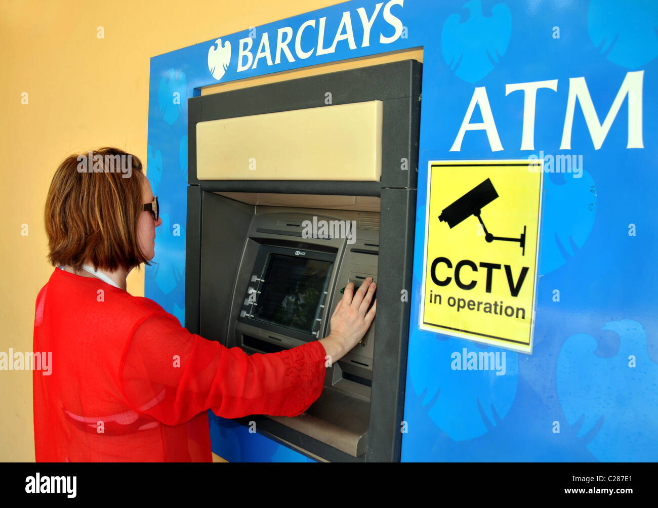 La direction de la Barclays Bank et ATM. Distributeur de l'aide femme. Banque D'Images