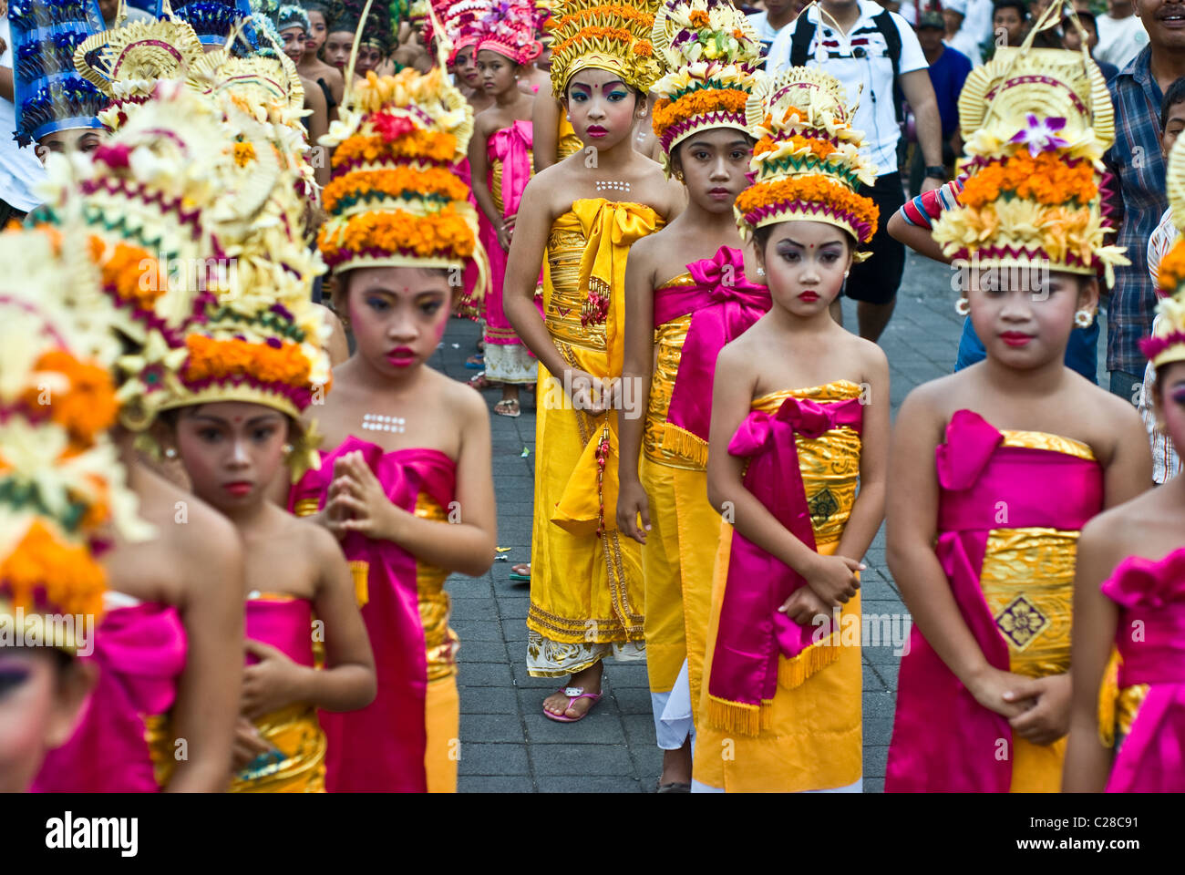 Les jeunes filles apportent balinais offrandes faites à partir de fleurs pour une cérémonie traditionnelle sur leur tête. Banque D'Images