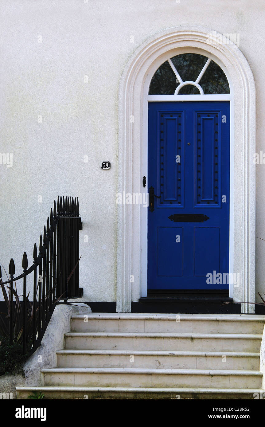 Une porte d'entrée d'une maison avec des marches et des rampes menant à la porte d'entrée bleue UK Banque D'Images