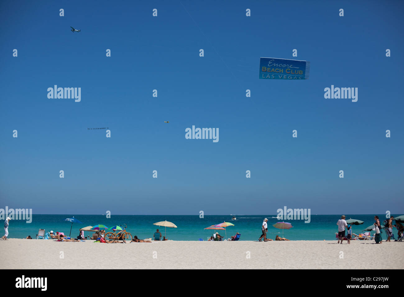 Avion avec message publicitaire survolant la Beach, South Beach, Miami, Floride, USA Banque D'Images