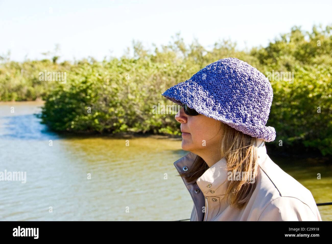 Profil d'une femme en bonnet et lunettes de soleil, avec vue sur la rivière  qui serpente dans une forêt Photo Stock - Alamy