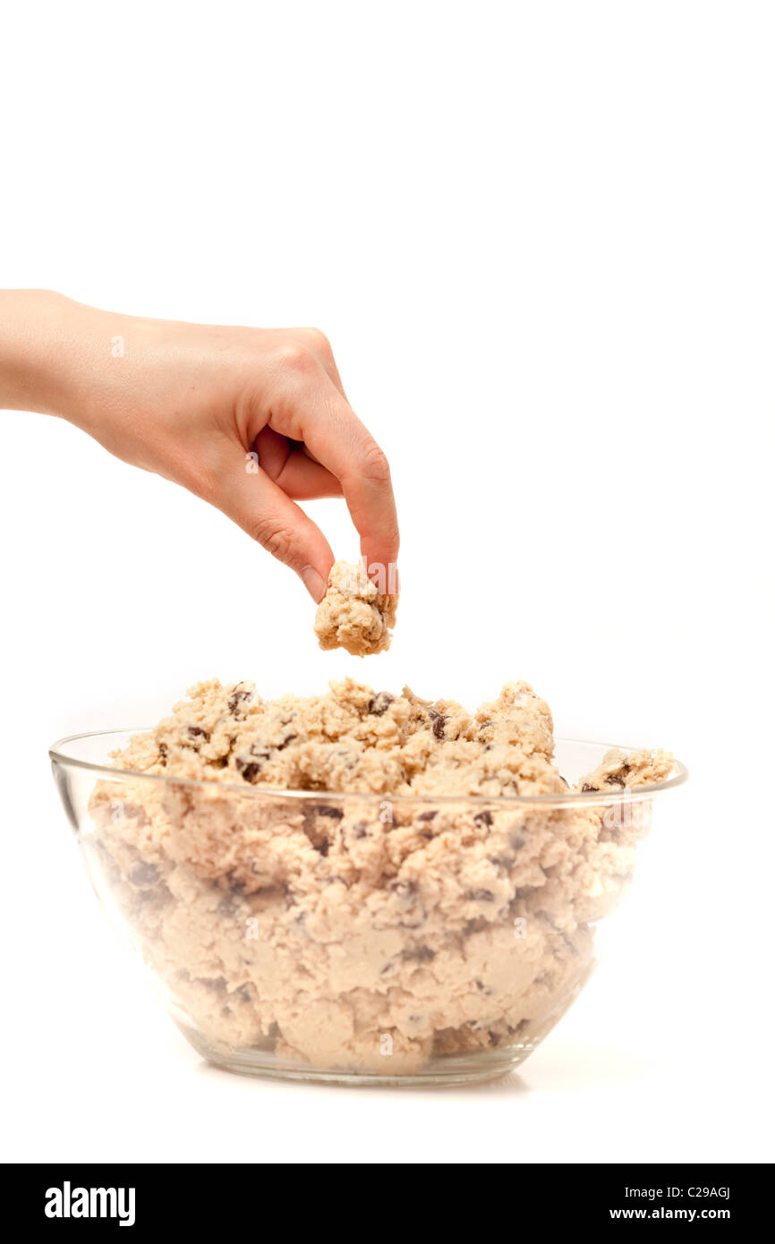 Une main se faufiler un test de goût de pâte à biscuits. Banque D'Images