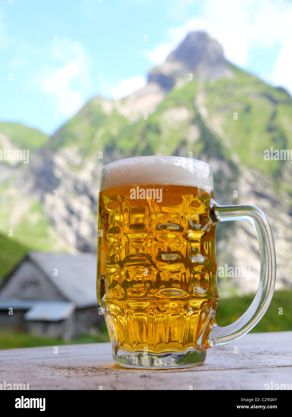 Grand verre de bière sur une table en bois en face d'un paysage de montagne  Photo Stock - Alamy