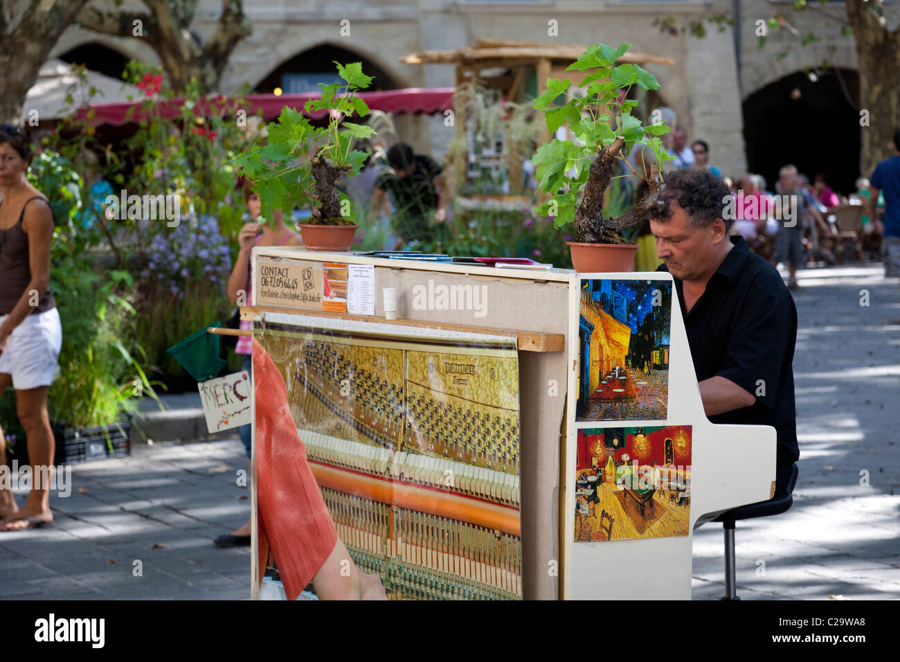 Le pianiste joue pour les consommateurs et aux touristes de passage dans le centre d'Uzès, Gard, Languedoc-Roussillon, France. Banque D'Images
