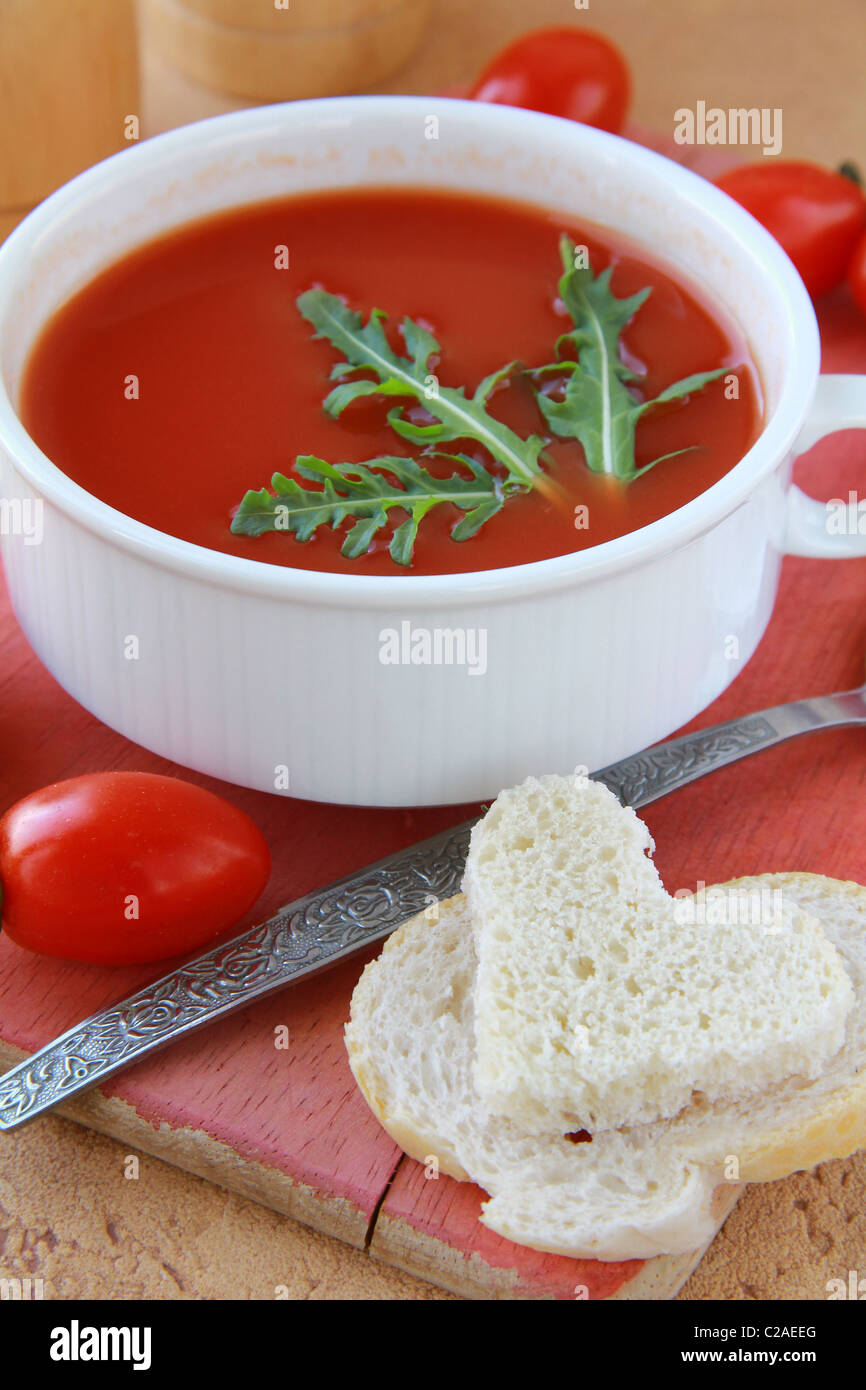 Soupe de tomate dans un bol blanc de roquette et tomates cerises Banque D'Images