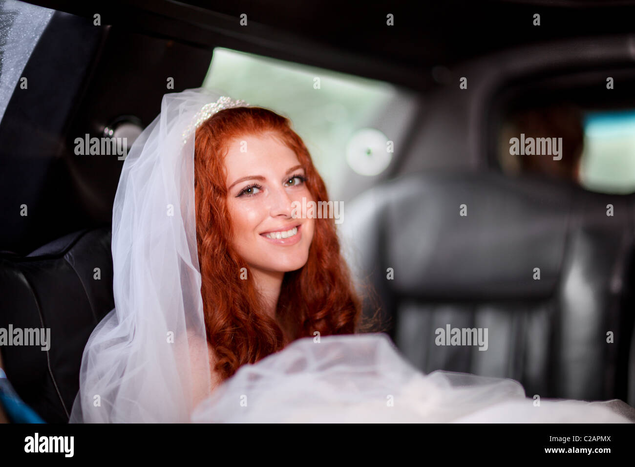 Cheveux rouge jeune mariée dans la limousine en route pour la cérémonie. Communiqué de modèle signé. Banque D'Images