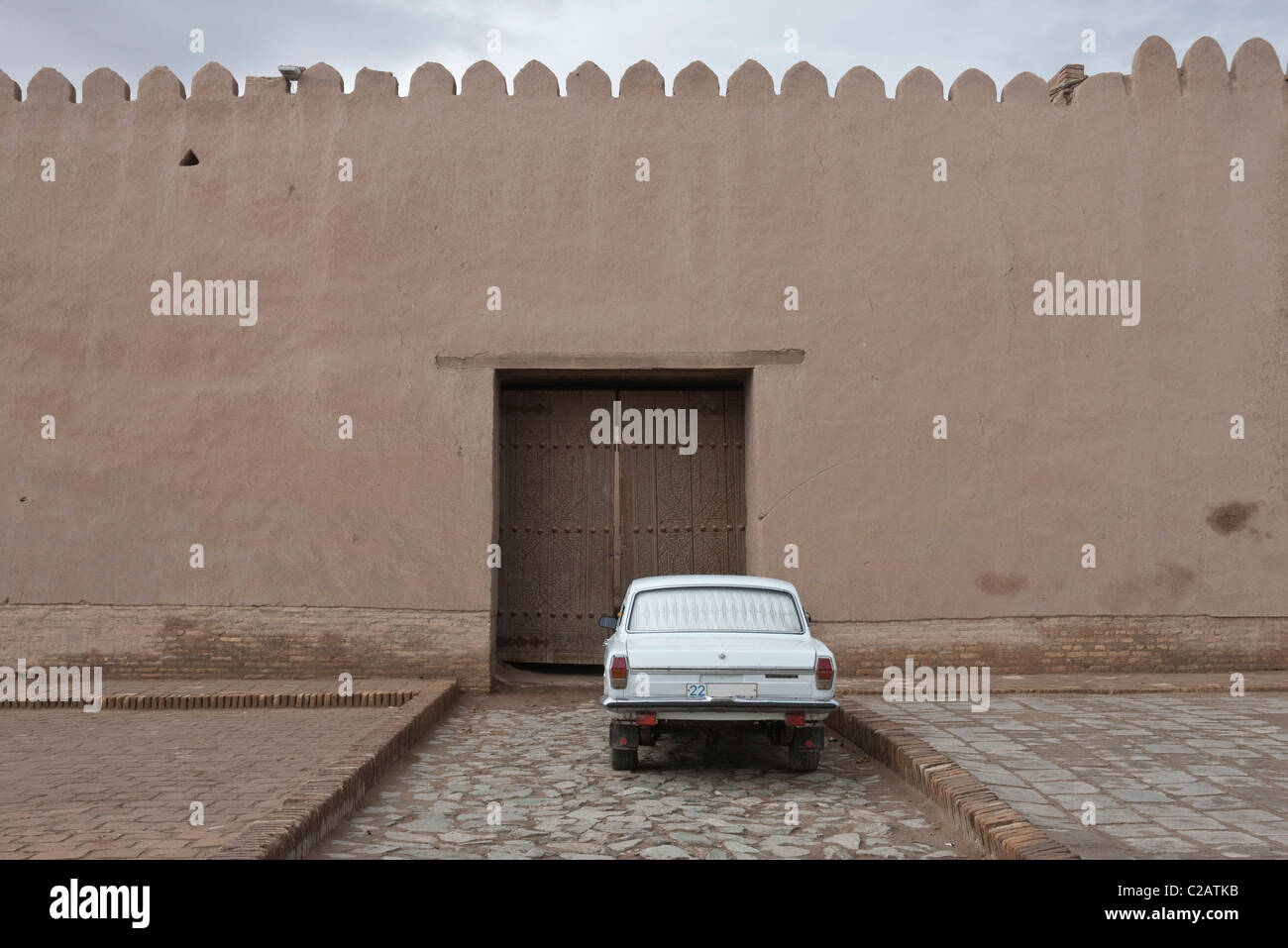 L'Ouzbékistan, Khiva, Itchan Kala, voiture garée en face de l'ancien mur de la ville Banque D'Images