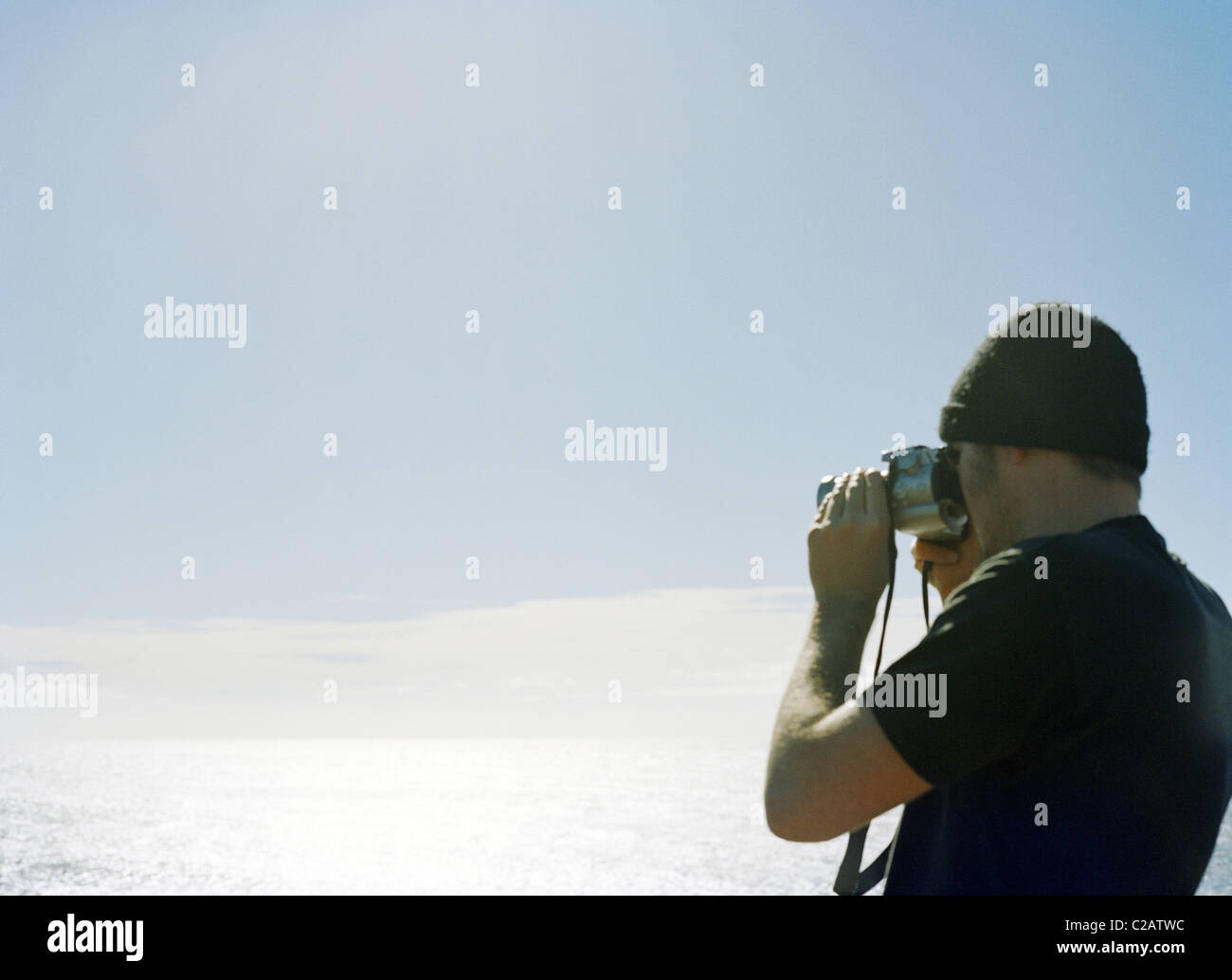 Man photographing ocean view avec appareil photo Banque D'Images