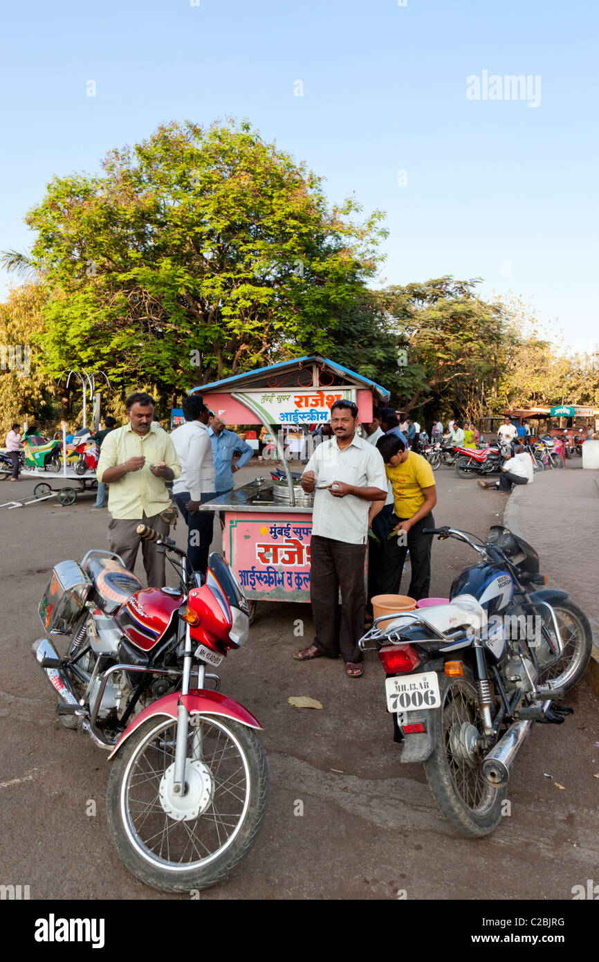 Les hommes indiens eating ice cream à un vendeur de rue en Inde Sholapur Banque D'Images