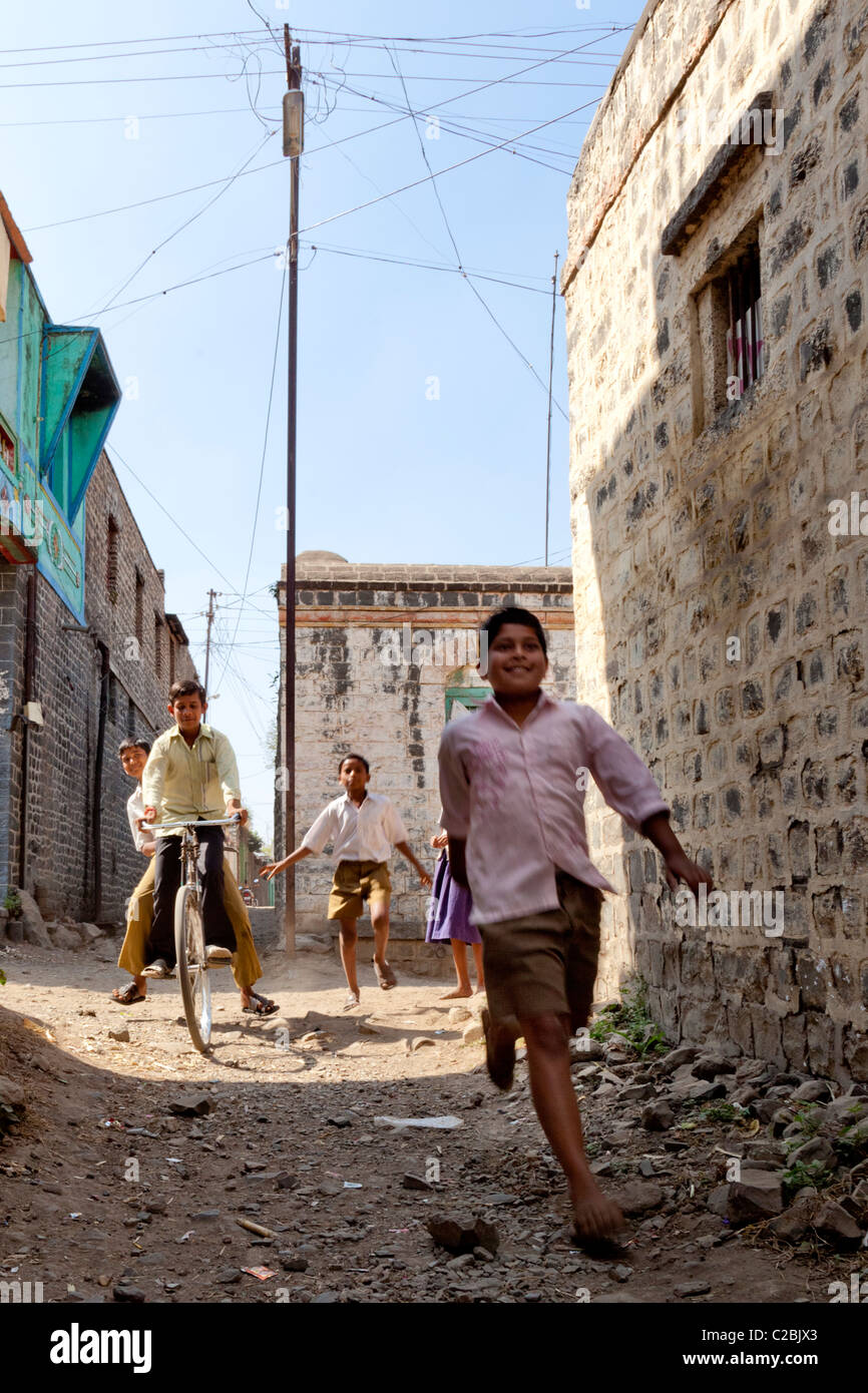 Les enfants courent vers le bas une ruelle dans le village d'Valsang Maharashtra Inde Banque D'Images