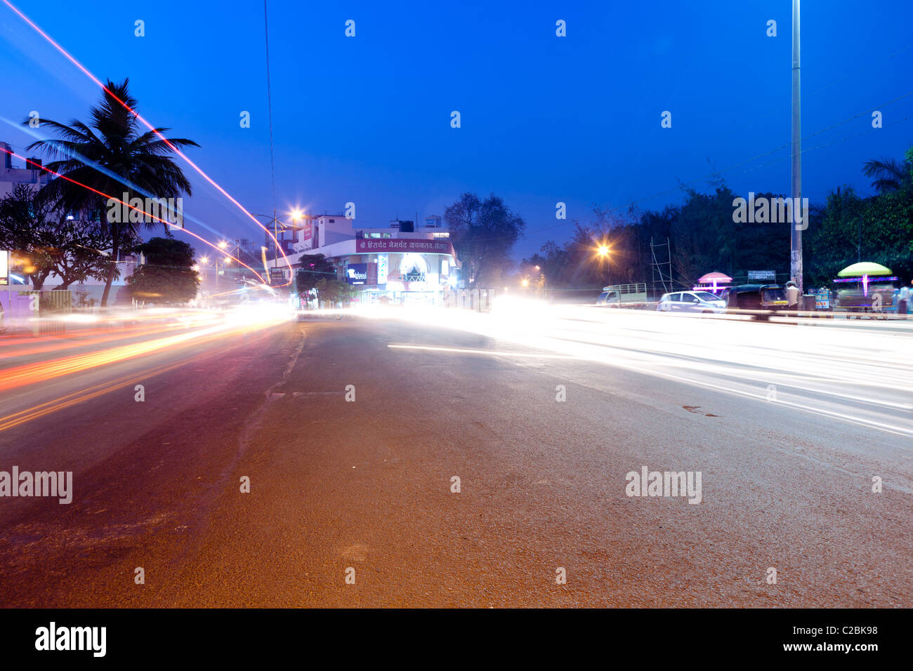 Les sentiers de la lumière provenant de la circulation sur une rue animée au crépuscule en Sholapur Inde Banque D'Images
