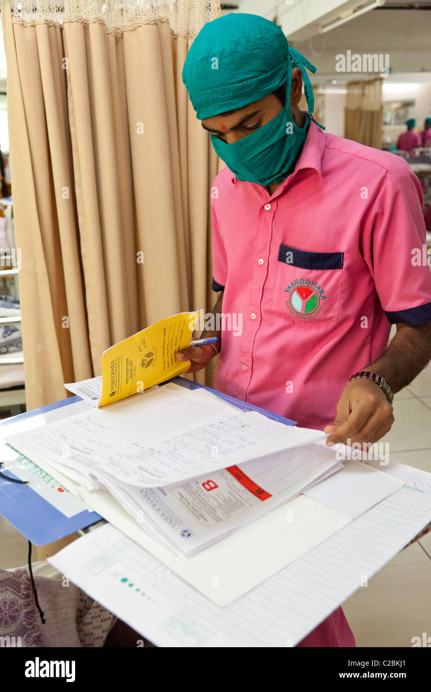 Une infirmière vérifie une note les patients dans une unité de soins intensifs (USI) de l'hôpital de Yaçodhara Sholapur Inde Banque D'Images