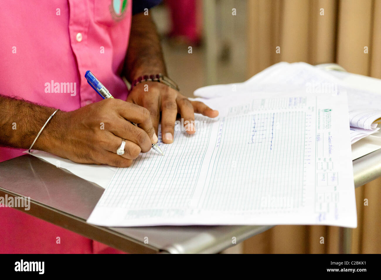 Une infirmière rédige des notes dans les patients d'une unité de soins intensifs (USI) de l'hôpital de Yaçodhara Sholapur Inde Banque D'Images