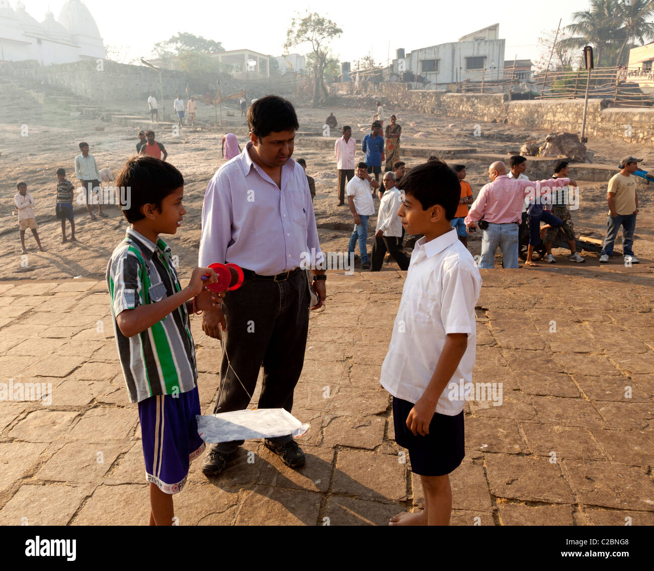 L'homme indien garçons enseignement comment voler un cerf-volant sur un emplacement tournage à Mumbai Maharashtra Inde Banque D'Images