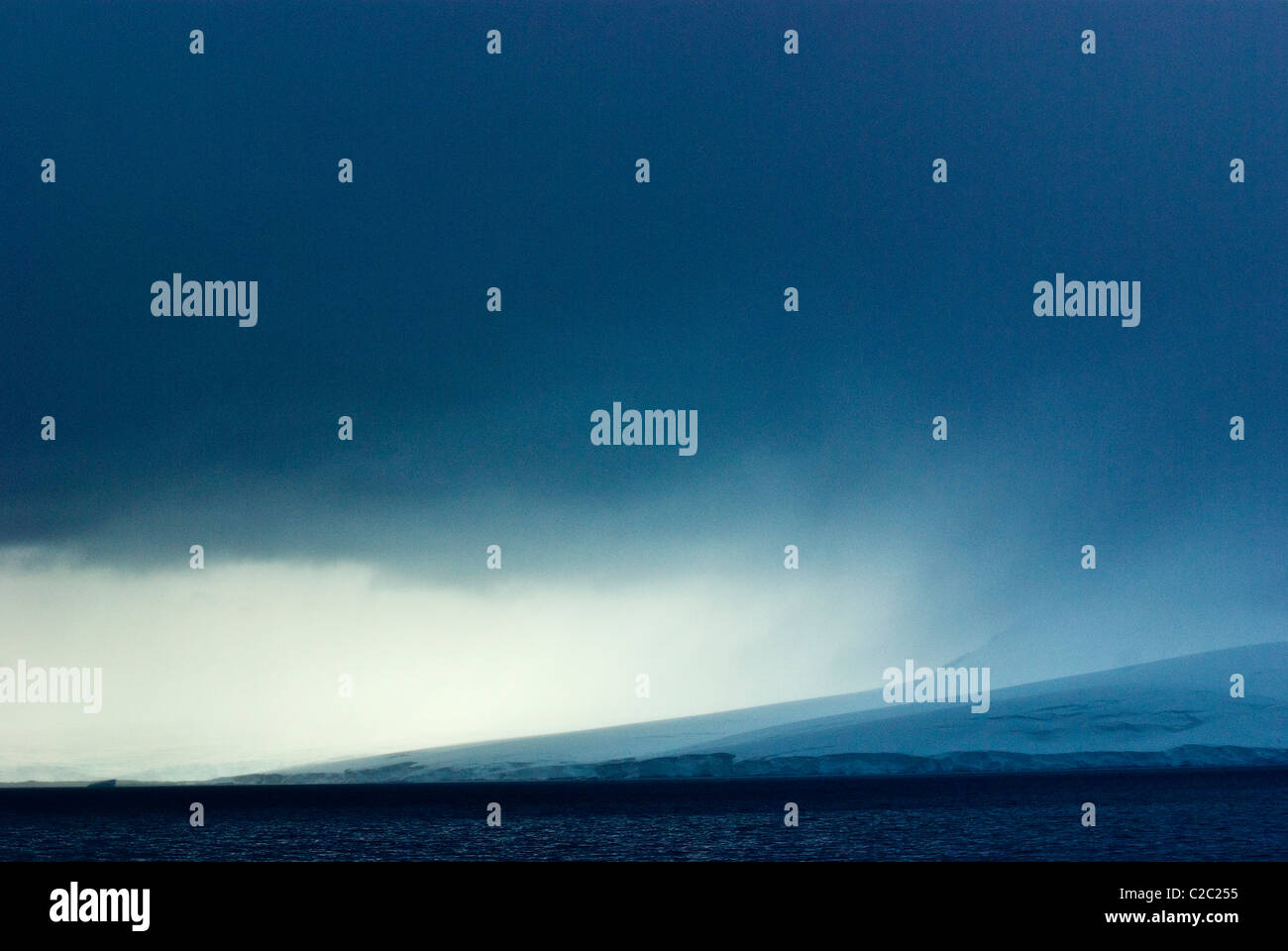 Une tempête menaçante descend sur un glacier énorme tournant dans la mer. Banque D'Images