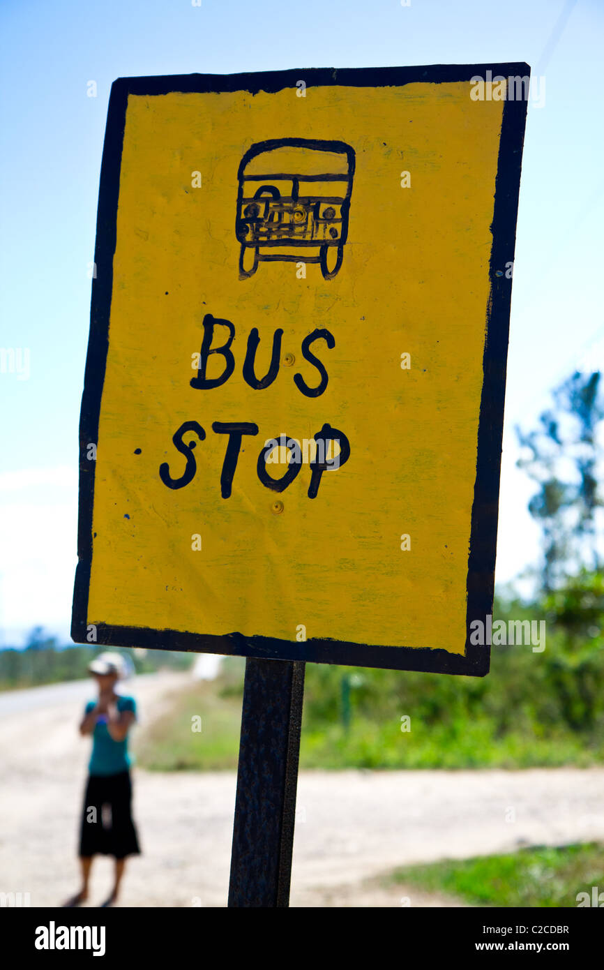 Une figure solitaire attend un bus à Belize. Banque D'Images