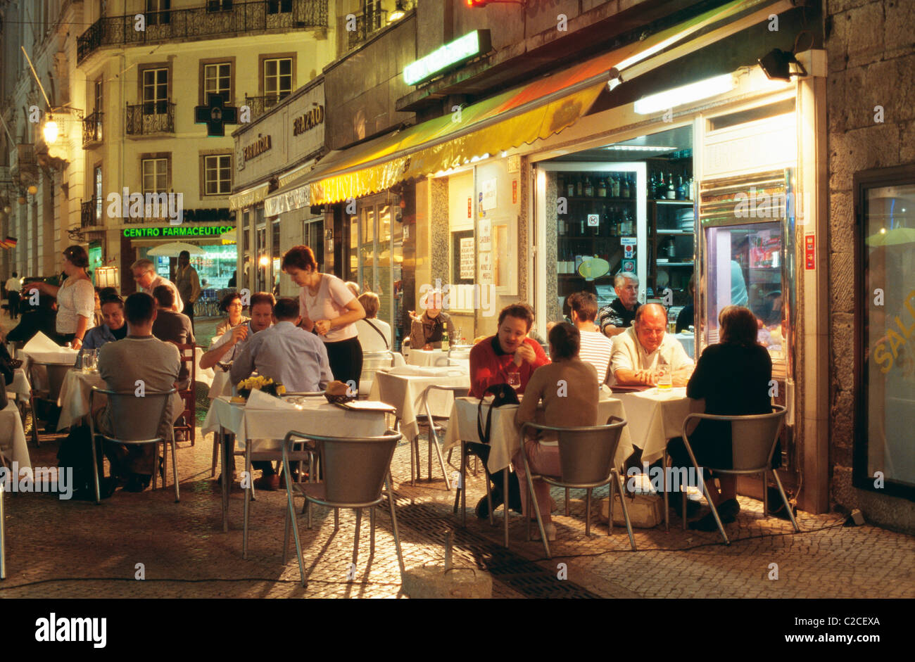 Ruelles de quartier de Baixa comme Rua das Portas S Antao encombrée de petits restaurants où les gens mangent à des tables sur la rue Banque D'Images