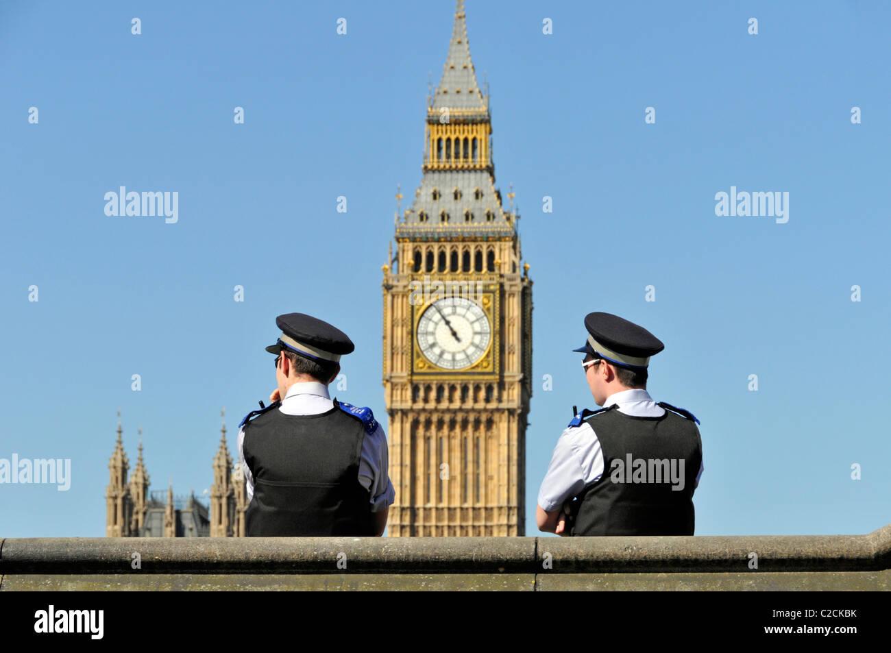Deux officiers de soutien de la communauté de police métropolitaine avec Big Ben Beyond lors d'un ciel bleu de printemps à Westminster Londres Angleterre Royaume-Uni Banque D'Images