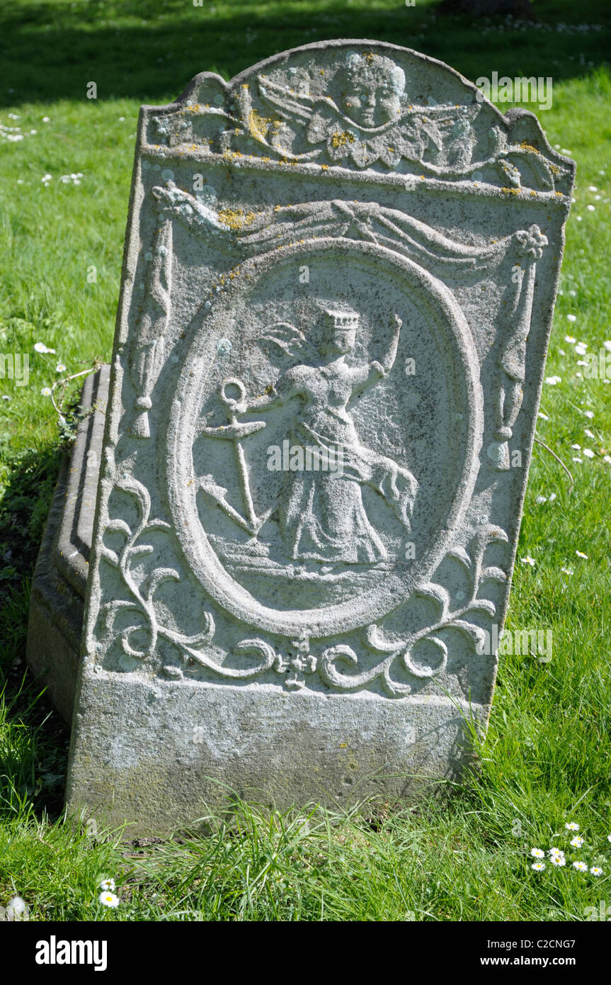 Détail d'une femme portant une couronne et tenant une ancre, sculptés sur pierre tombale dans un cimetière à Sudbury, Suffolk, UK. Banque D'Images