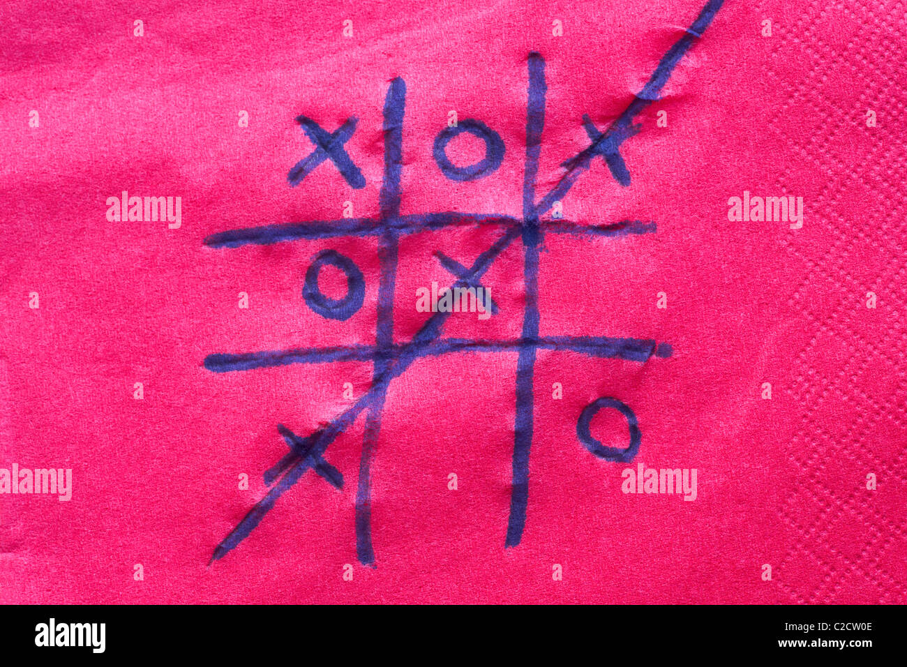 Jouer un jeu de noughts et croix noughts & croix écrit à l'encre de stylo sur une serviette rose serviette Banque D'Images