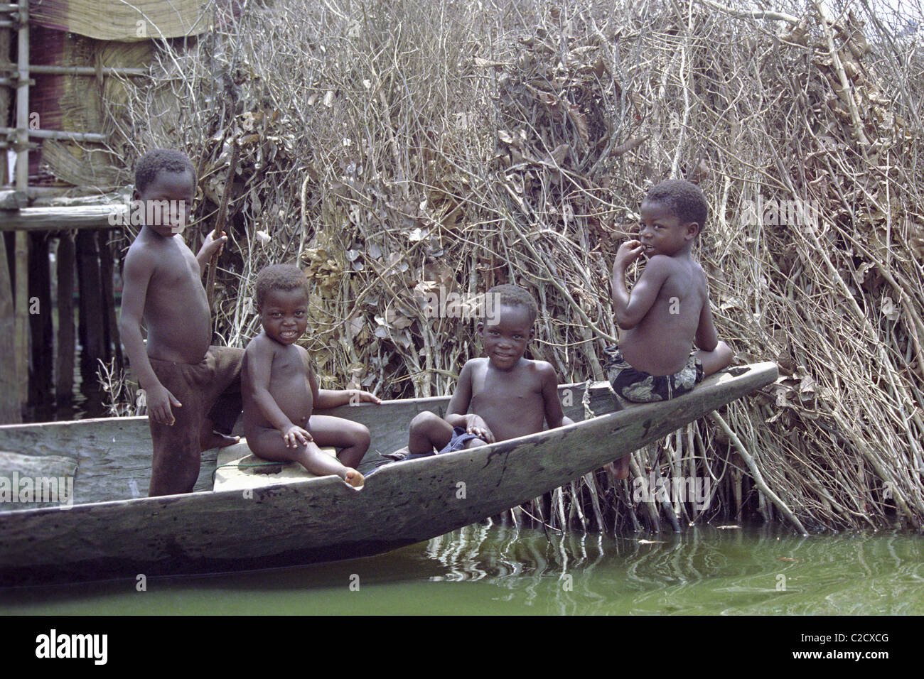 Les enfants en canoë, Ganvie, Bénin. Banque D'Images