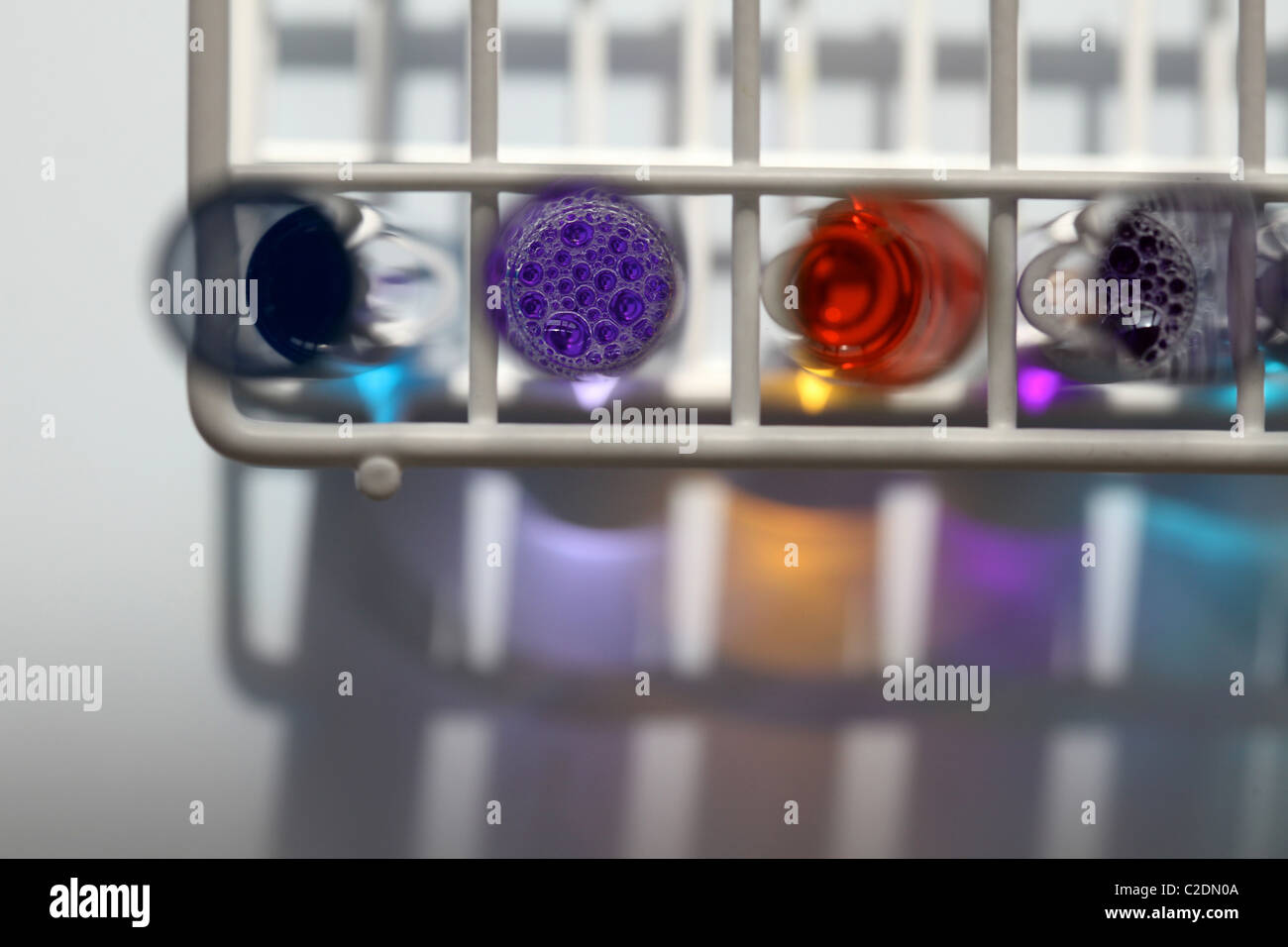 Ariel sur rack de quatre tubes à essai dans un laboratoire contenant des liquides de différentes couleurs Banque D'Images