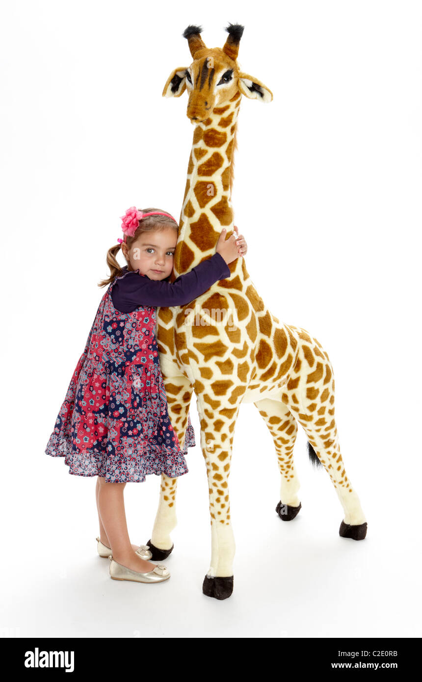 Petite fille jouant avec un jouet girafe farci Banque D'Images