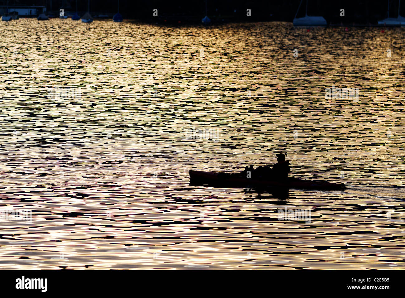 Un homme en kayak comme silhouette au coucher du soleil contre l'eau de couleur rouge, de concept pour se détendre, méditer, Banque D'Images