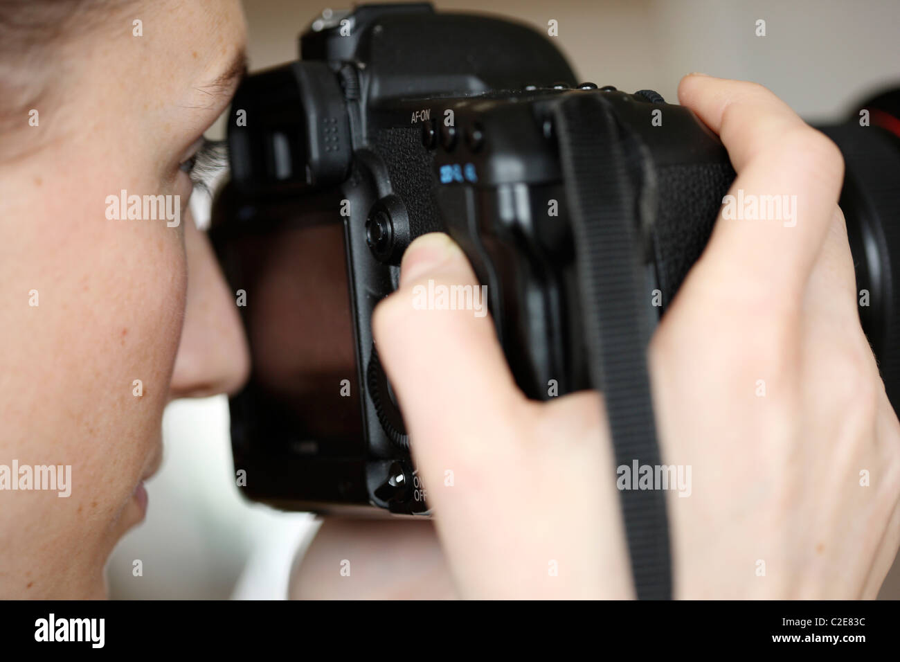 Personne, femme, regarde à travers le viseur d'un appareil photo numérique à objectif interchangeable. Banque D'Images