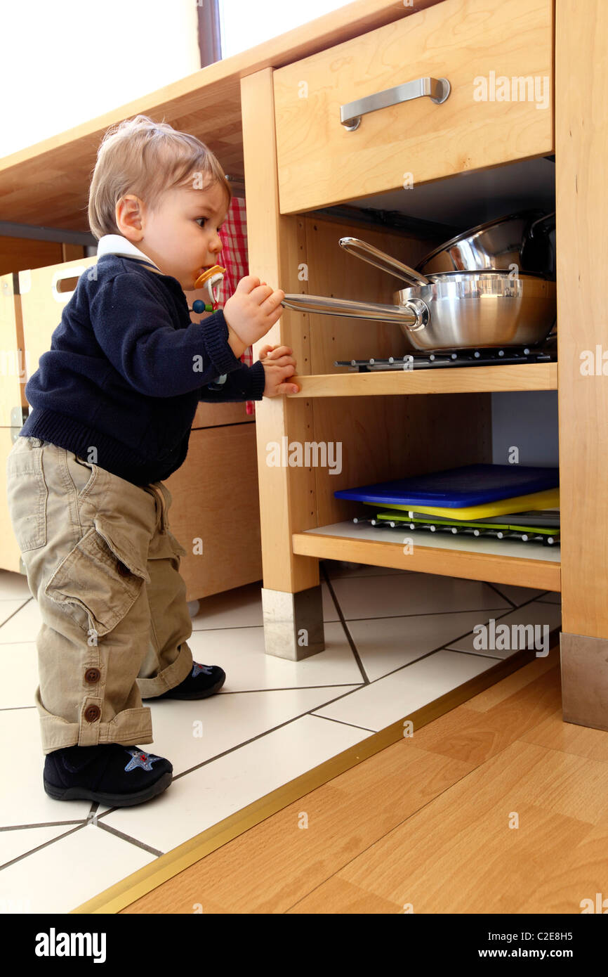 Petit Garcon Bebe 10 Mois Est D Explorer La Cuisine Joue Avec Des Ustensiles De Cuisine Supprime Les Pots D Armoire De Cuisine Photo Stock Alamy
