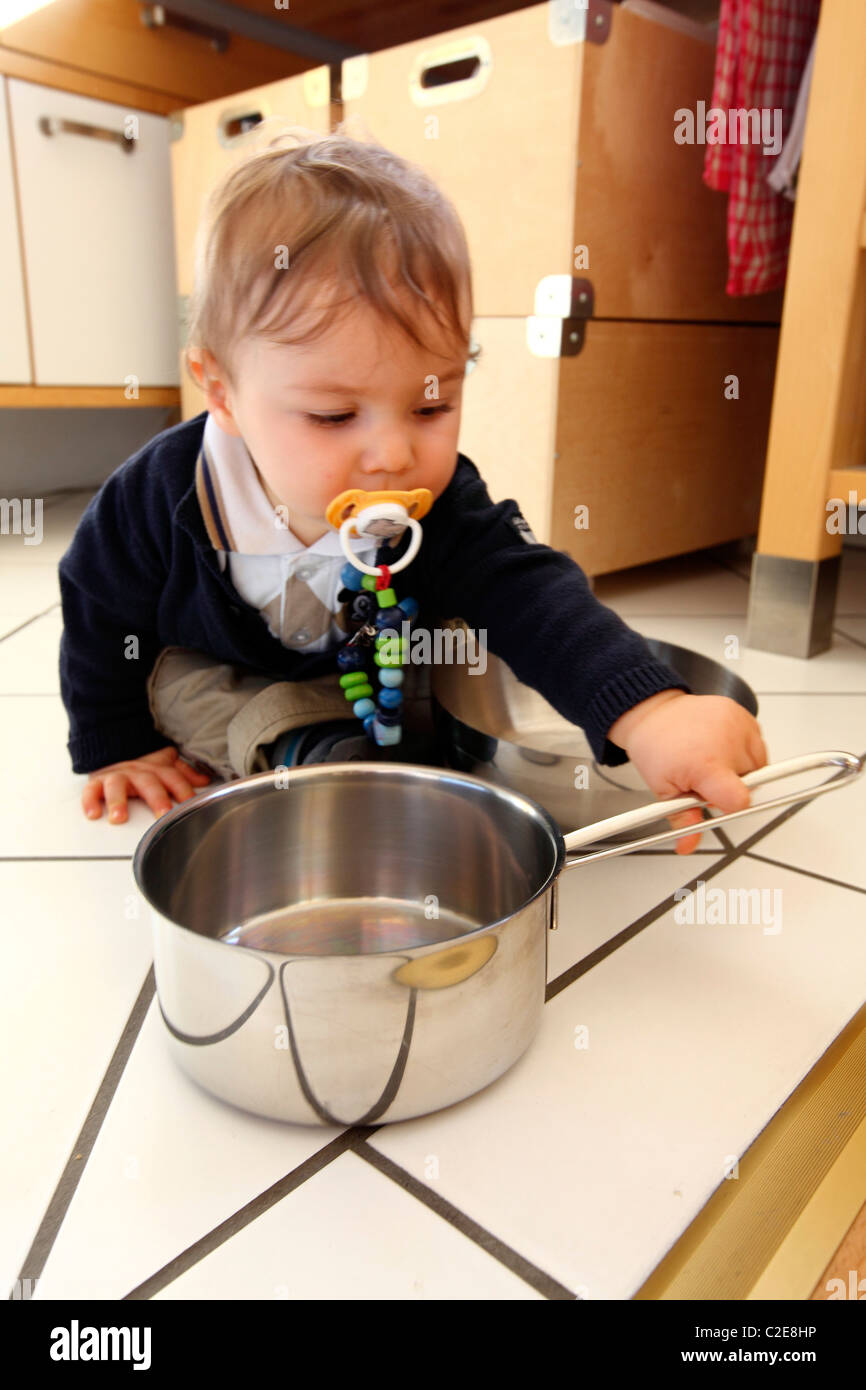 Petit Garcon Bebe 10 Mois Est D Explorer La Cuisine Joue Avec Des Ustensiles De Cuisine Supprime Les Pots D Armoire De Cuisine Photo Stock Alamy