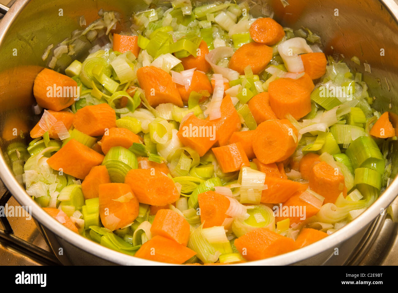 Les carottes, les fuites et les oignons Browning comme base de soupe de légumes Banque D'Images